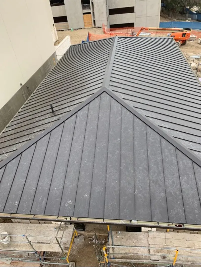 Commercial metal roof construction with crane equipment in Rossville